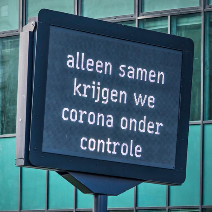 Afbeelding met bord waarop staat alleen samen krijgen we corona onder controle