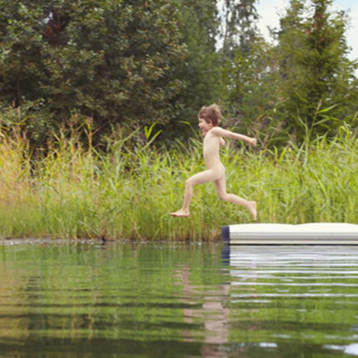jongen springt van steiger in het water