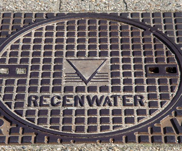 detail van putdeksel met daarop het woord regenwater