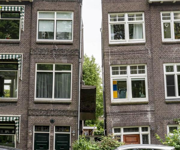 Twee scheefgezakte huizen in een stad
