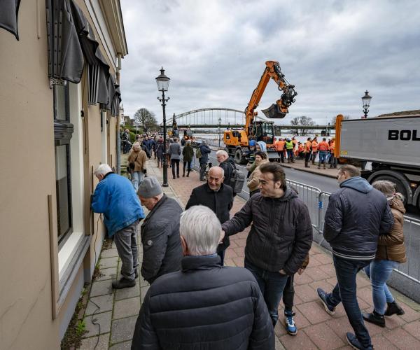 Mensen in de weer langs een rivier bij hoogwater