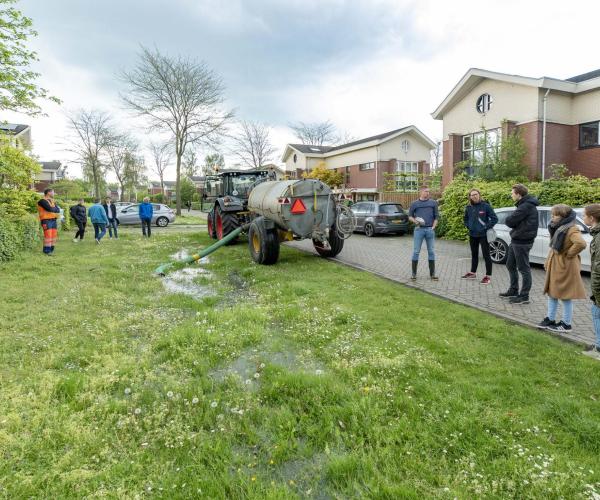 Traktor laat water uit aanhangwagen afvloeien in wadi
